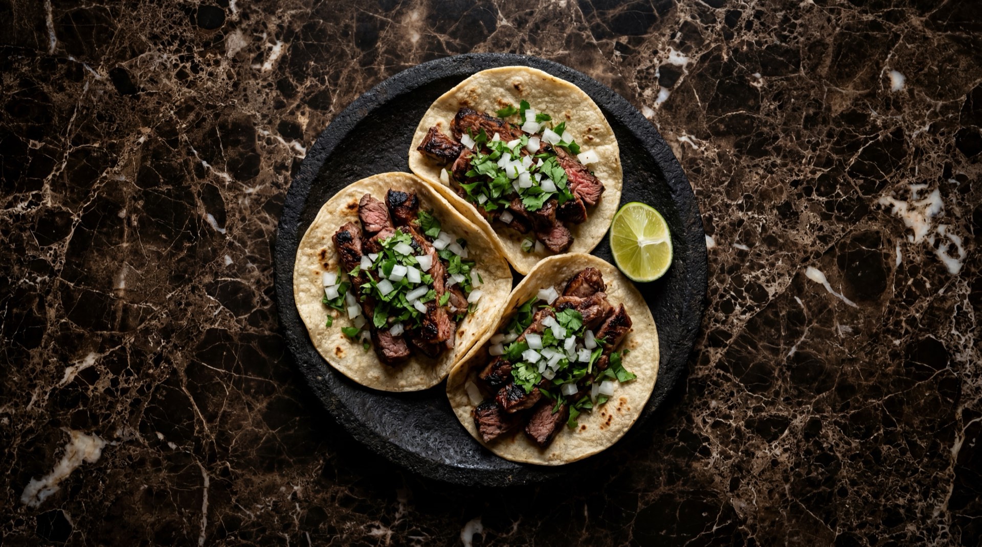 Tacos de carne asada mexicanos con cilantro fresco picado y cebolla blanca sobre tortilla de maiz doble en plato de barro negro