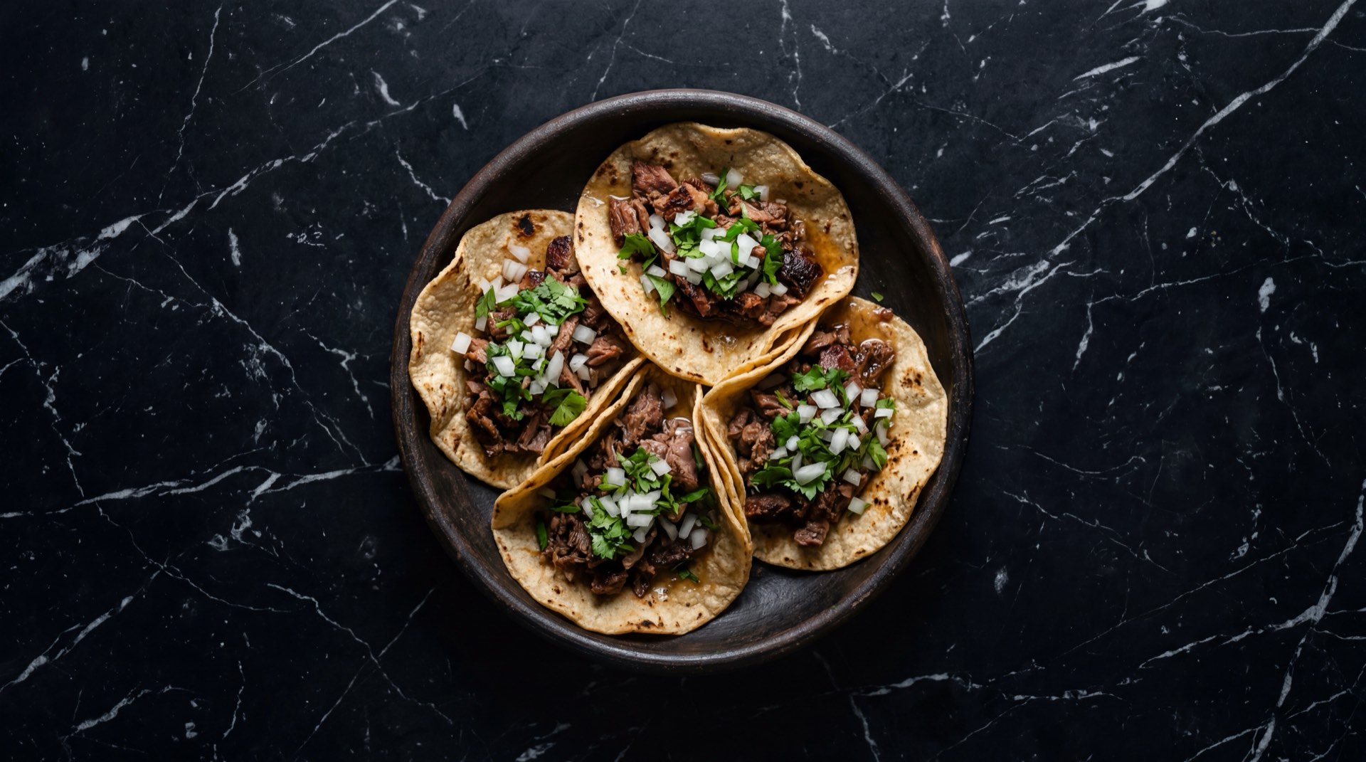 Tacos de suadero mexicanos estilo CDMX con suadero de res dorado, cebolla blanca picada, cilantro fresco y salsa roja de chile de arbol sobre tortilla de maiz doble en plato de basalto volcanico