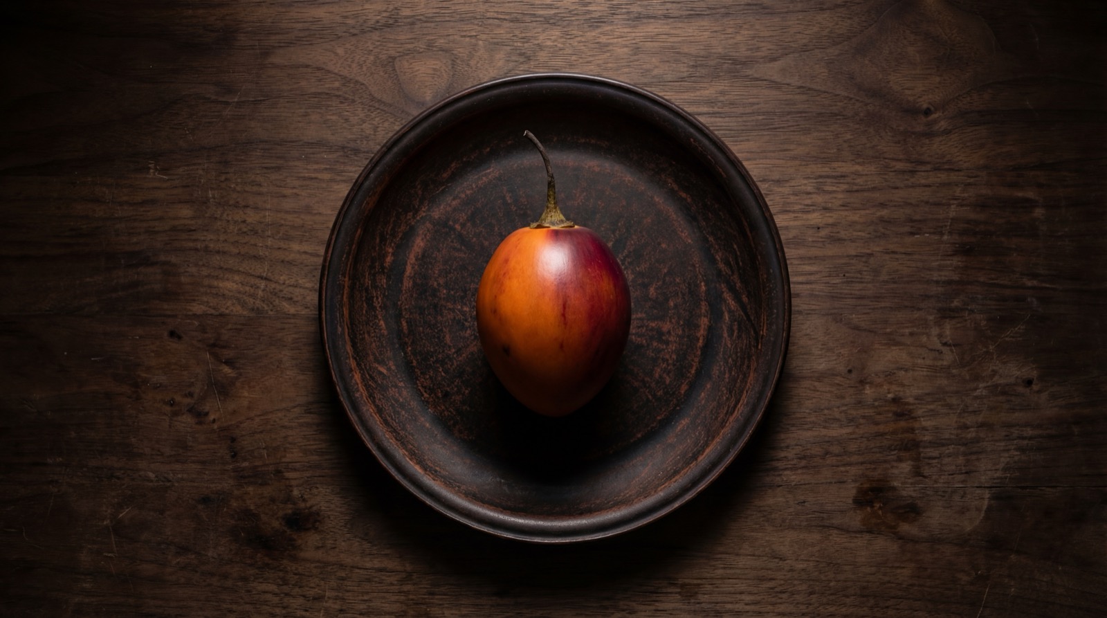 Tomate de arbol entero y cortado mostrando su pulpa naranja con semillas