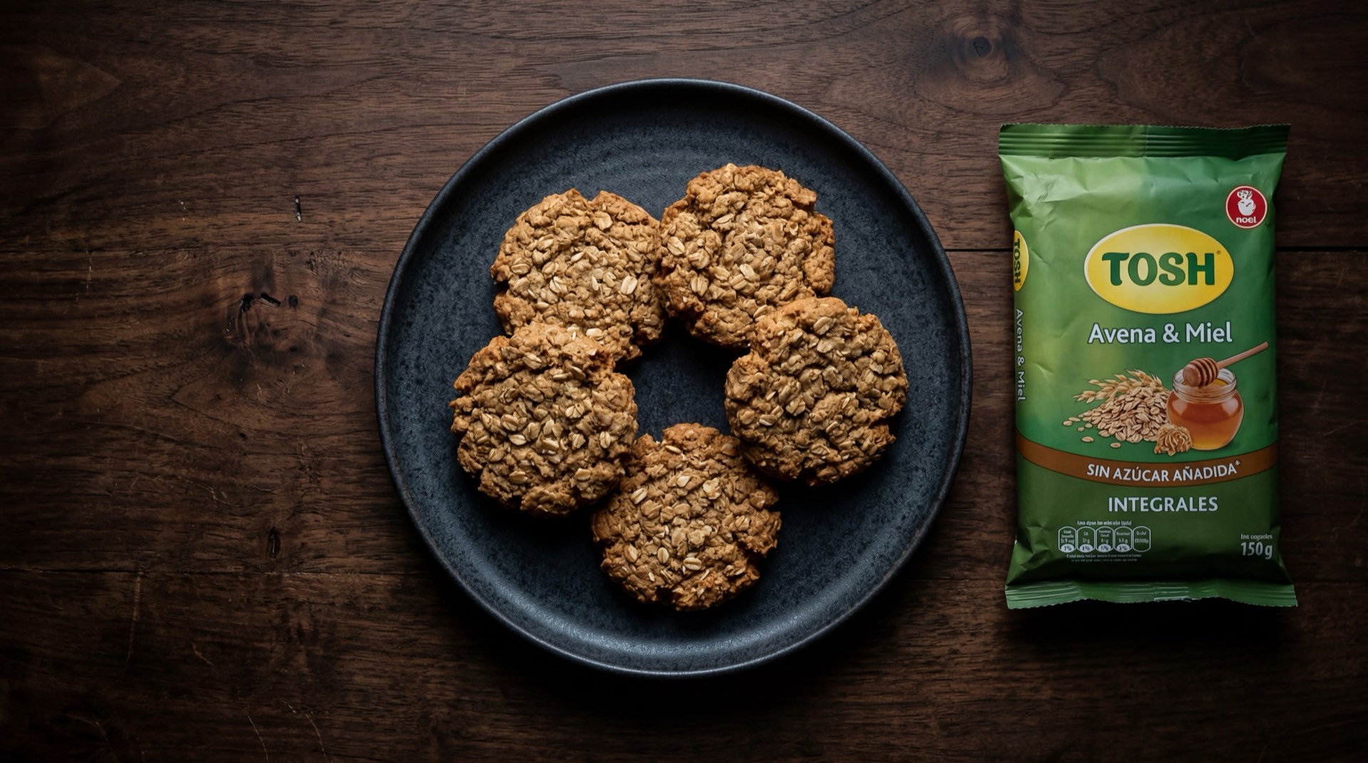 Galletas Tosh de Noel, paquete de galletas integrales de avena y miel sobre mesa de marmol negro con vetas doradas