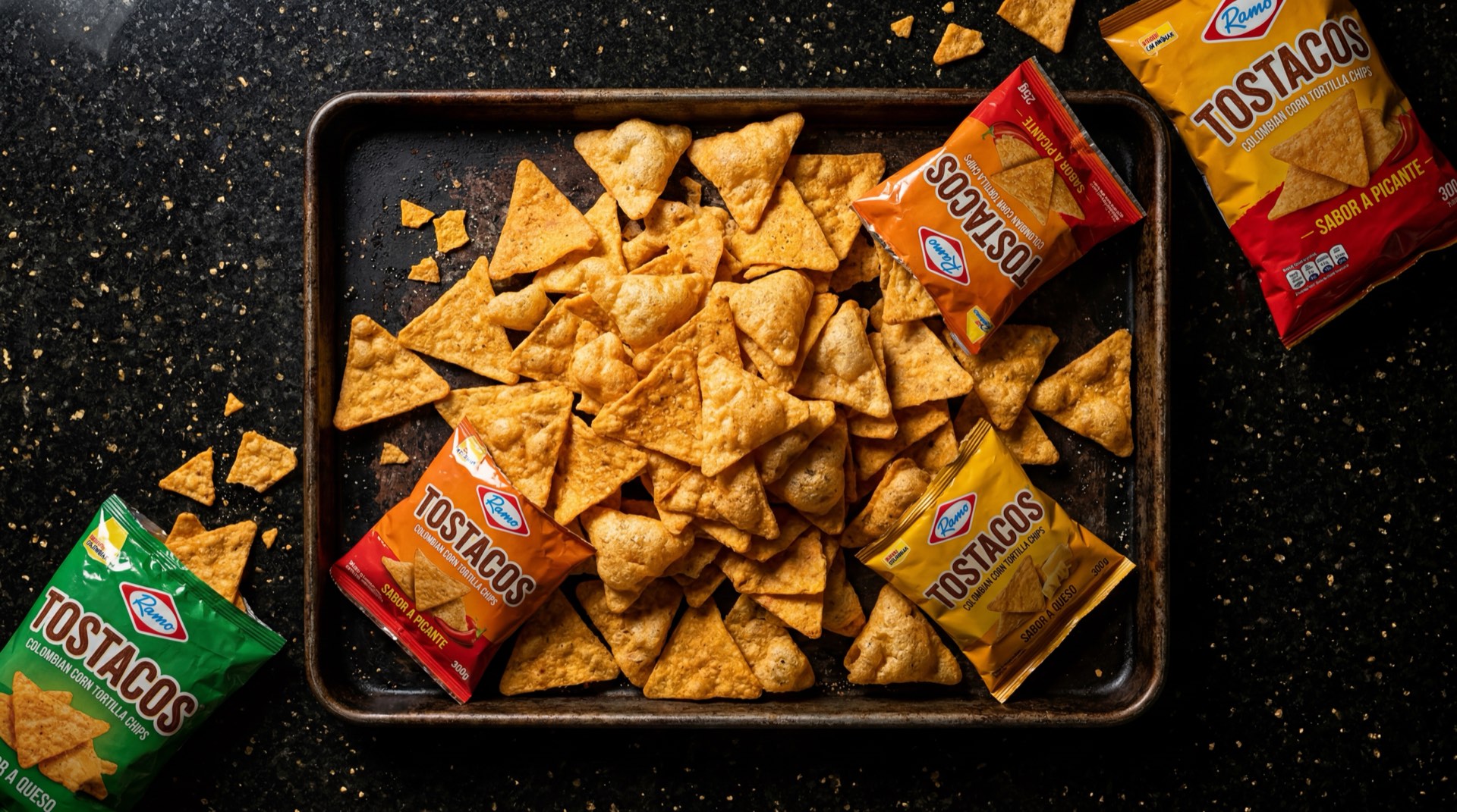 Tostacos Ramo, tortillas de maiz tostadas tipo chip en paquete individual sobre mesa de marmol oscuro