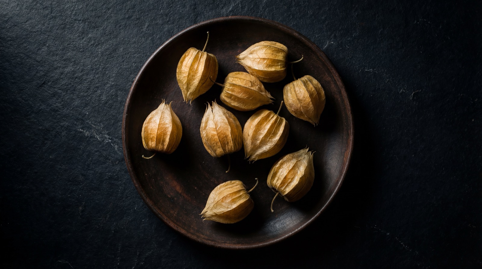 Uchuvas con y sin su envoltura de hoja seca mostrando la baya dorada