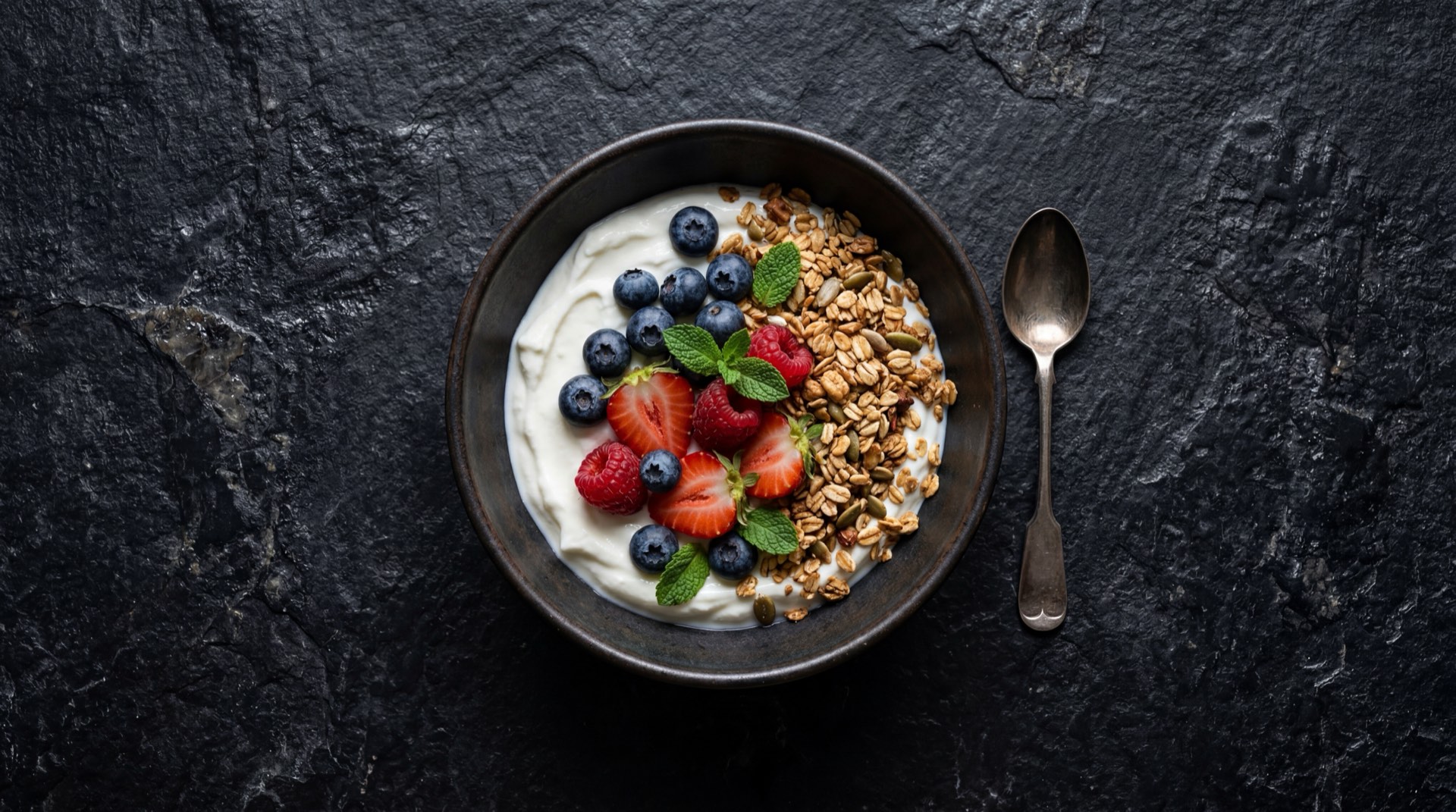 Version saludable del yogurt Alpina: yogur griego natural sin azucar con frutos rojos frescos, semillas de chia hidratadas y avena integral cruda